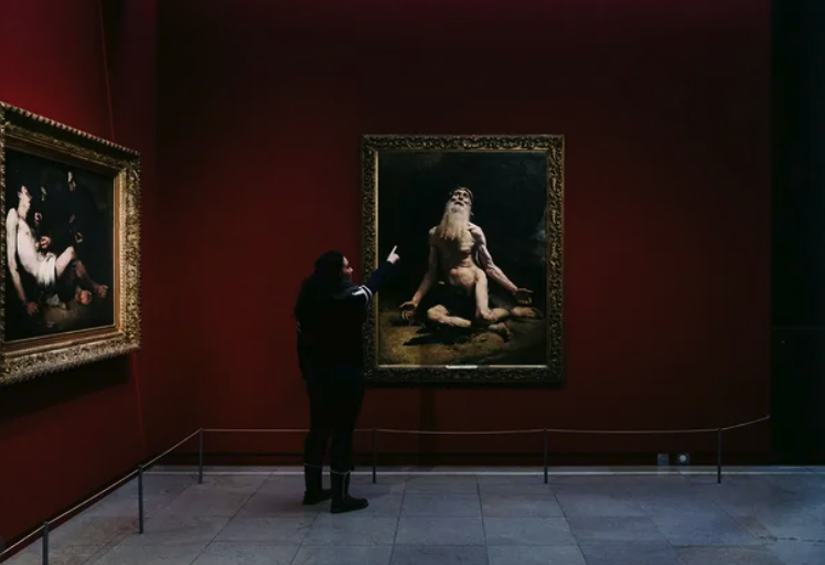 A guide talking to a small group in front of a painting at the Musée d'Orsay